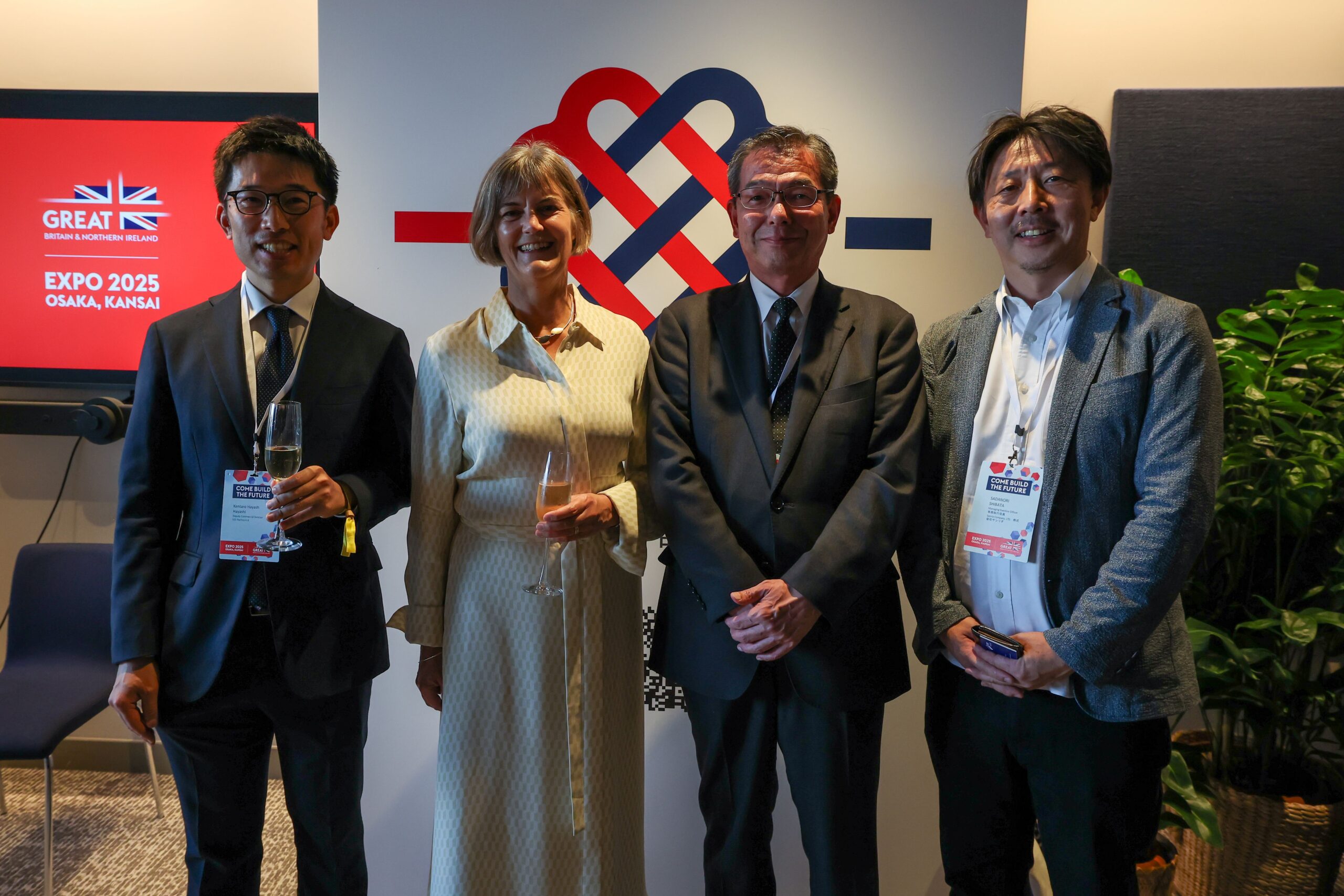 British Ambassador standing with three MUSUBI pioneer partners in front of MUSUBI banner at UK National Day, World Expo, Osaka Kansai 2025